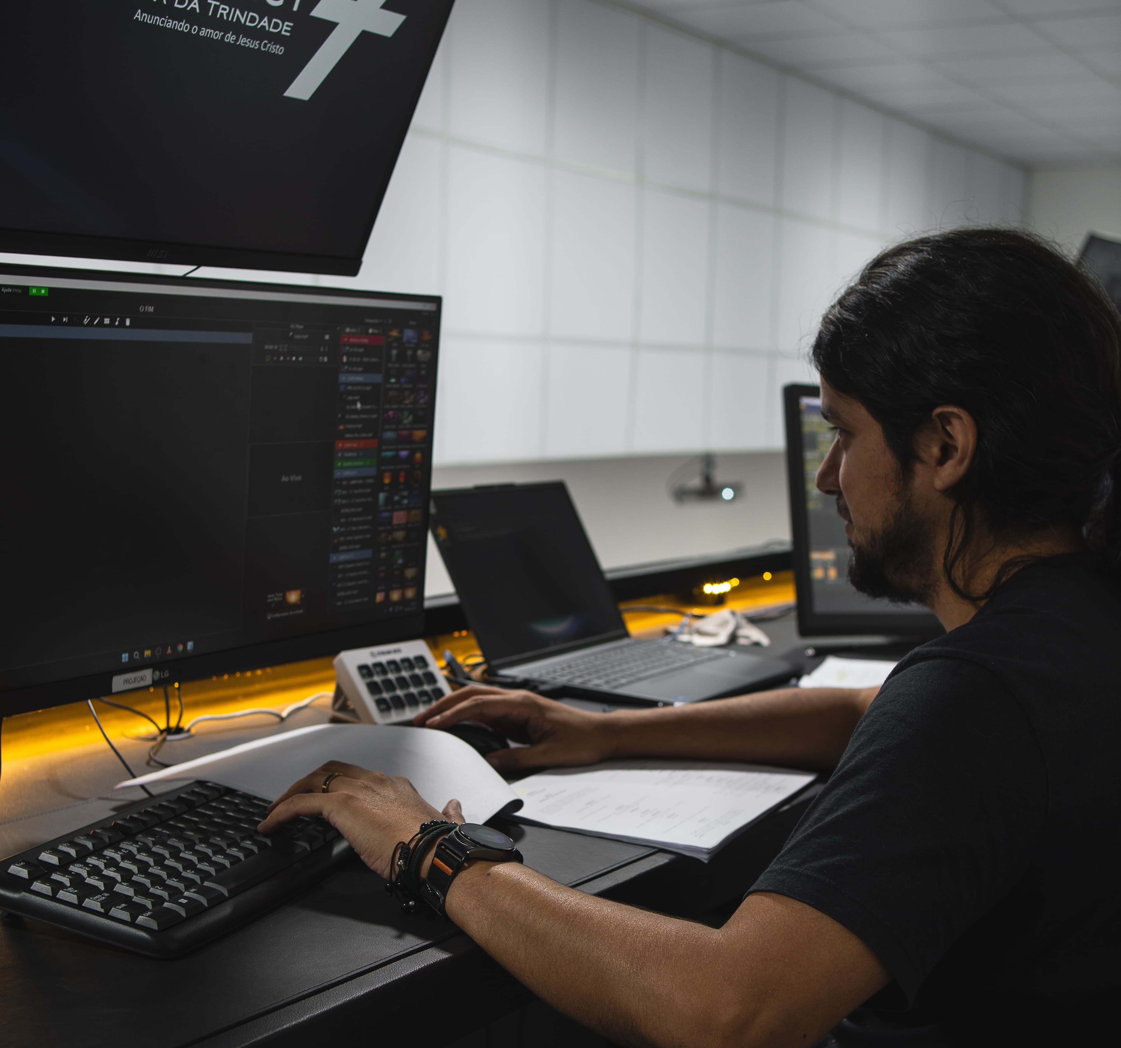 Voluntário controlando a projeção no computador durante o culto